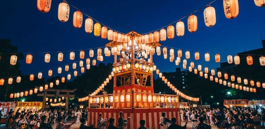 夏の夜の盆踊り会場で頭上に飾られた無数の提灯を下から見上げた写真